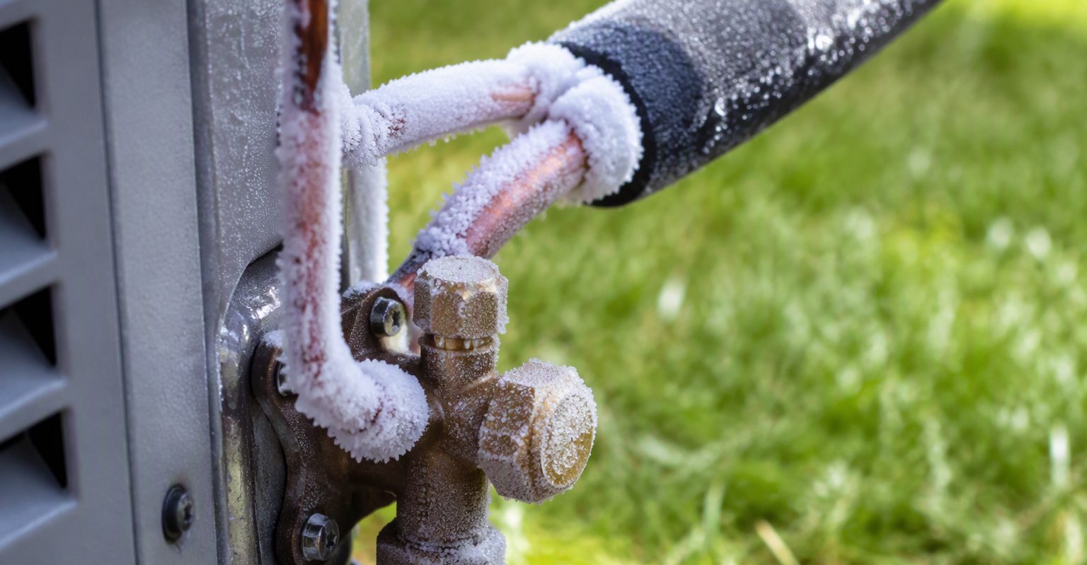 Ice-coated refrigerant lines on an outdoor AC unit